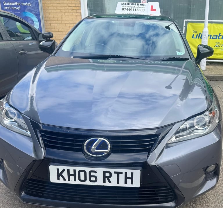 Silver Lexus sedan with KH06 RTH registration plate parked at a car dealership